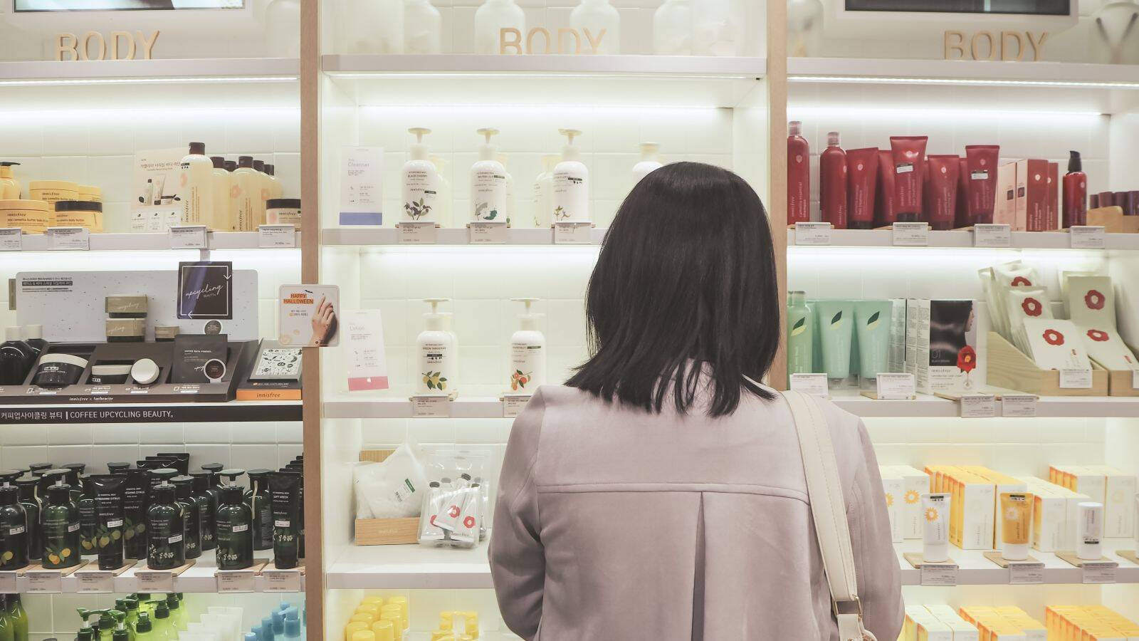 asian woman front shelp skincare products